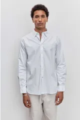 Camisa de manga larga en color celeste, con cuello clásico y cierre frontal de botones. Presenta un diseño de corte recto y acabado liso.