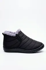 Botas cortas de nailon acolchado en color negro, con interior y reborde forrados en piel sintética gris. Cuentan con elásticos laterales para facilitar el calce y suela plana de goma.