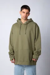 Buzo canguro oversize de tela friza, color negro, con capucha, cordones ajustables con logo y bolsillo frontal tipo canguro.