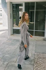 Pantalón de tiro alto con pierna ancha, confeccionado en sarga color tostado. Presenta detalle de doble hilera de botones metálicos dorados en el frente y pinzas verticales.