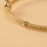 Pulsera extensible de malla en oro 18k, con diseño bicolor en oro amarillo y blanco, y detalle de esfera central pulida.