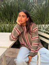 Sweater de tejido de punto de algodón con diseño rayado en color blanco, bordó y rosado, cuello redondo a la base, mangas largas acampanadas y silueta oversize.