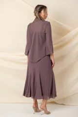 Vestido midi de crepé color marrón, compuesto por un vestido solera de corte al bies con terminación en godet y una casaca a juego. Ambas piezas presentan delicados apliques de piedras al tono con diseño ornamental.