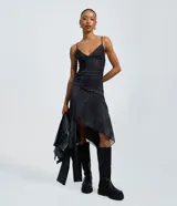 Vestido midi de tule con estampado de cuadros, breteles finos ajustables y ruedo asimétrico. Presenta un diseño ajustado en el torso con falda fluida y forro interior.
