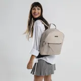 Mochila color beige con aplique de cuero sintético en la parte inferior y superior. Tiene un bolsillo frontal con cierre y un bolsillo interno. Las correas son regulables.