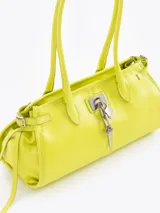 Cartera tipo shoulder bag de cuero vacuno en color amarillo, con doble asa de hombro, cierre superior y detalles de tiras laterales colgantes. Incluye aplique de cerradura metálica con candado y llavero colgante en el frente.