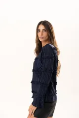 Blusa de manga larga en color azul marino, confeccionada en tejido plisado con detalles de volados horizontales a lo largo de toda la prenda.
