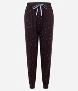 Conjunto de pijama compuesto por una remera de manga larga con cuello redondo y detalle de lazo, y un pantalón tipo jogger. Ambas piezas presentan un estampado de corazones pequeños sobre un fondo oscuro.