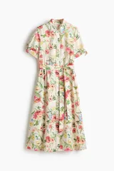 Vestido midi de corte camisero con estampado floral multicolor sobre base beige, cuello camisero, botonadura frontal completa, mangas cortas con lazo y cinturón del mismo género para ajustar en la cintura.