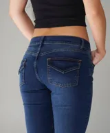 Jean azul de tiro medio, corte ajustado y diseño clásico con bolsillos traseros con solapa y costuras en contraste.
