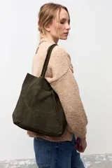 Bolso tipo tote de gamuza en color verde oscuro, con diseño minimalista, doble asa de hombro y cierre mediante cordón ajustable en la parte superior.