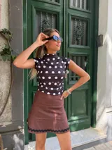 Minifalda marrón de gabardina elastizada con detalle de puntilla negra en el ruedo.