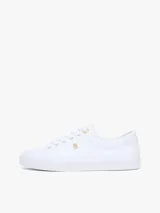 Zapatillas Tommy Hilfiger modelo Lulu Gold, de color blanco y diseño de corte bajo. Están confeccionadas en capellada sintética con cordones blancos, ojetes metálicos dorados y forro interno de algodón. Presentan detalles distintivos de la marca y monograma TH en el lateral.