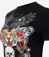 Remera de algodón con escote redondo y mangas cortas, de corte ajustado al cuerpo y color negro. Presenta un estampado frontal de estilo tattoo flash con un tigre, una calavera, panteras y rosas, acompañado de la inscripción "Liberty" y detalles de brillos termosellados.