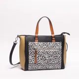 Bolso tipo tote bag de mujer, con paneles de diferentes texturas y colores: negro liso, negro con estampado de dálmata/animal print, y laterales en color camel con textura de cocodrilo. Posee asas de mano en color camel y una correa larga ajustable negra.