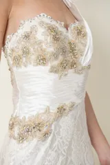 Vestido largo de novia blanco con encaje, corsé drapeado de un solo hombro y bordado en piedras.