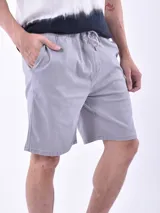 Bermuda de hombre color gris oscuro, de corte regular y largo hasta la rodilla, con cintura elástica y cordón de ajuste.