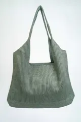 Bolso tipo tote bag de tela color verde oliva con textura acanalada.