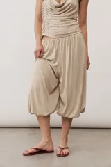 Pantalón holgado negro tipo bombacho, con cintura elástica y puños fruncidos en los tobillos.