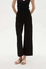 Pantalon tipo jean de corte flare y tiro alto, color verde oscuro, con cierre frontal y bolsillos.