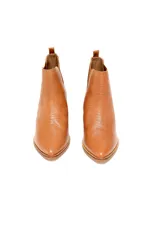 Bota tipo chelsea de cuero vacuno con textura grabada, color caramelo. Presenta elásticos laterales en tono marrón oscuro, puntera almendrada y taco bajo recto de madera.