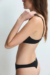 Conjunto de lencería negro compuesto por un corpiño sin aro con detalles de tul transparente y una bombacha de tiro alto con recortes de tul en la cintura.