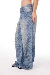 Pantalón jean oversized de tiro bajo, color azul lavado, con estampado de tigresa grabado con láser.