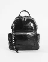 Mochila negra de cuero sintético con acabado brillante, doble cierre superior, bolsillo frontal con cierre y bolsillos laterales abiertos. Incluye un llavero decorativo con tachas plateadas.