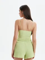 Musculosa de textura fruncida en color verde menta, con escote recto y breteles finos.