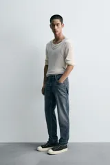 Pantalón de jean corte slim fit, color gris con efecto lavado. Presenta diseño de cinco bolsillos, cierre frontal con cremallera y botón, y tejido elástico.