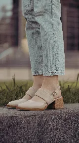 Zapato de taco ancho y medio, color negro, confeccionado en cuero. Presenta diseño destalonado con tira ajustable en el talón, faja ancha de gamuza sobre el empeine y puntera fina de charol.