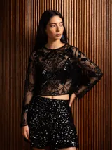 Blusa de microtul negro con bordados intrincados y aplicaciones de lentejuelas, de corte cropped y manga larga.