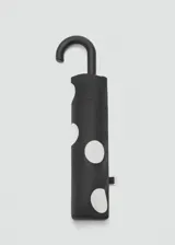 Paraguas plegable negro con estampado de lunares blancos y mango curvado de plástico negro.