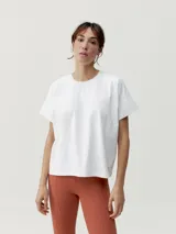 Camiseta blanca de manga corta con corte oversize y cuello redondo. Presenta un sutil estampado en relieve o tono sobre tono en el pecho y la espalda.