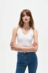 Musculosa blanca de bretel ancho, con cuello en V y ajuste al cuerpo.