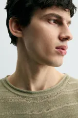 Jersey relaxed fit de punto ligero color verde claro, con rayas horizontales en un tono más claro. Tiene cuello redondo amplio, manga larga y acabados en rib.