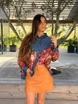 Camisa oversize combinada que mezcla denim azul en la parte superior y mangas, con tela vintage de estampado geométrico y tribal multicolor en la espalda y mangas. Presenta cuello camisero y corte holgado.