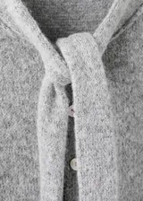 Cardigan de punto gris melange, de manga corta, con cuello redondo y cierre frontal de botones con tiras integradas para atar en forma de lazo.