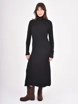 Vestido midi de punto color negro, con cuello alto y mangas largas, de corte ajustado en la parte superior y falda ligeramente acampanada.