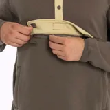 Buzo marrón con cuello alto con botones, tapeta color beige y bolsillo tipo canguro con etiqueta de la marca.