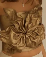 Top strapless de cuero genuino color cobre con diseño artesanal de flor central con pétalos drapeados. Estructura maleable y espalda regulable.