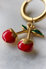 Aros de acero quirúrgico hipoalergénico, con argolla pequeña y dije colgante en forma de cerezas.