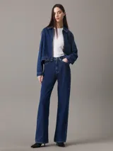 Jeans de mezclilla azul oscuro, talle alto, con corte bota (bootcut) y pierna ancha.