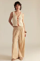 Top tejido de punto color crudo, con escote en V y borde tejido en color salmón.