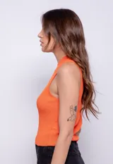 Top negro de tejido de punto, sin mangas, con cuello alto y cut-out en el pecho con avíos metálicos.