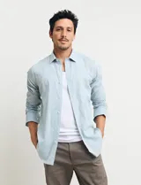 Camisa sport de manga larga con cuello buttondown, confeccionada en una mezcla de algodón y lino. Presenta un diseño clásico en color celeste con cierre frontal de botones.