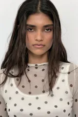 Top de punto fino semitransparente con cuello subido y manga larga, con estampado de lunares.