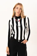 Polera de tejido de punto con diseño de rayas verticales anchas en blanco y negro, cuello alto y manga larga.