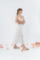 Vestido largo negro con top tejido en crochet y falda de gasa liviana con caída natural. Escote halter con breteles que atan al cuello y detalle de puntilla en la unión del busto.