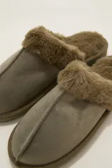 Pantuflas cerradas color marrón con ribetes de piel sintética en la abertura y suela plana.